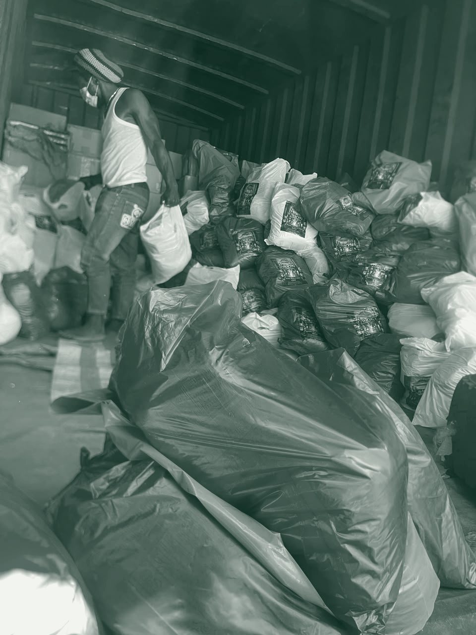 Volunteers unload bags of food from a delivery truck.